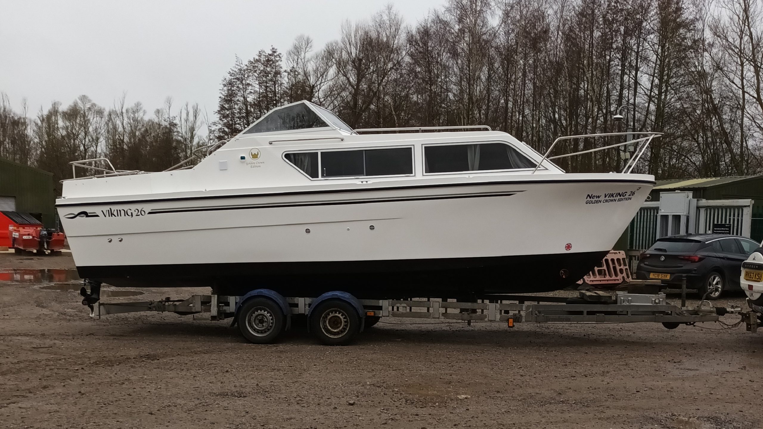 whote motor boat on a trailer in a boat yard